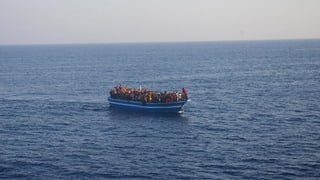Flüchtlingsboot mit Menschen im Meer