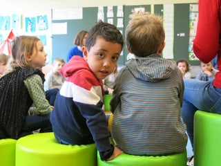 Kinder im Kindergarten, ein Junge schaut in die Kamera