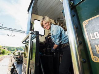 Sabine Dahinden schaut aus Führerstand der Dampflokomotive