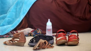 Schuhe und eine Milchflasche für ein Baby in einem Lager von aus Afghanistan Evakuierten.
