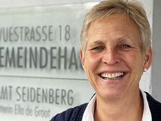 Portrtät der Pfarrerin vor dem Schild ihres Kirchgemeindehauses. Portrtät der Pfarrerin vor dem Schild ihres Kirchgemeindehauses.