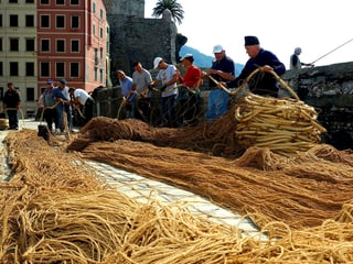 Fischer vor Netzen im Hafen von Camogli.