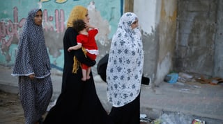 Drei palästinensiche Frauen mit einem Kleinkind verlassen ihr Haus