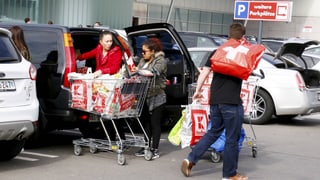 Zwei Frauen beladen ihr Auto mit Einkäufen. Zwei Frauen beladen ihr Auto mit Einkäufen.