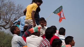 Gruppe von jungen Männern halten BJP-Fahne.