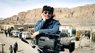 Christian Frei mit Kamera, Mütze und Sonnenbrille in Afghanistan.