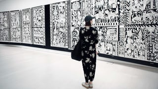 Eine junge Frau steht im Museum vor einem grossen schwarz-weissen Bild.