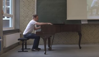 Ein Mann sitzt an einem Klavier.
