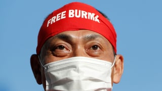 Ein Demonstrant trägt eine Hygienemaske und auf der Stirn ein Tuch mit der Aufschrift "Free Burma".