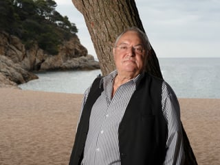 Porträt Mathias Gnädinger, im Hintergrund eine Meeresbucht.