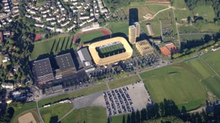 Luftaufnahme eines Gewerbegebietes mit Gebäuden und Grünflächen. 