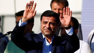 Selahattin Demirtas lächelt mit erhobenen Händen.