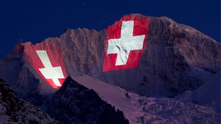 Symbolbild: Zwei riesige Schweizerkreuze werden auf die Jungfrau im Berner Oberland projiziert.