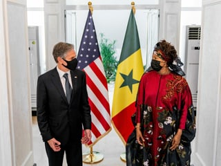 Antony Blinken steht neben Aissata Tall Sall für ein Bild. Hinter ihnen die US-amerikanische und die senegalesische Flagge.