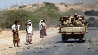 Ein Fahrzeug mit Soldaten fährt im Jemen auf einer Strasse.