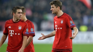 Philipp Lahm und Thomas Müller diskutieren auf dem Spielfeld.