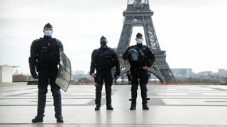 Französische Polizisten vor dem Eiffelturm in Paris.