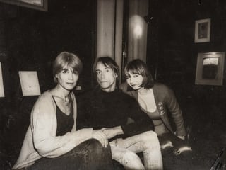 Schwarz-Weiss-Foto: Zwei Frauen und ein Mann sitzen nebeneinander und schauen in die Kamera. Schwarz-Weiss-Foto: Zwei Frauen und ein Mann sitzen nebeneinander und schauen in die Kamera.
