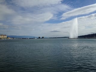 Der Genfer Jet d'eau, im Hintergrund die Stadt Genf.