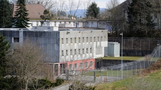 Dreistöckiges Gefängnis mit Zaun rundherum 