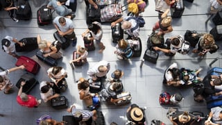 Flugpassagiere warten am Flughafen Zürich