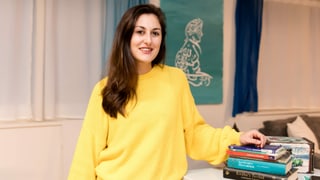 Eine Frau steht neben einem Tisch mit religiösen Büchern. Eine Frau steht neben einem Tisch mit religiösen Büchern.