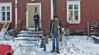Mann in Fellmütze vor einem Haus, es liegt Schnee. Mann in Fellmütze vor einem Haus, es liegt Schnee.