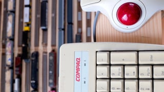 Ein Trackball neben einer Computertastatur.