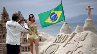 Auf einer Sandburg weht eine brasilianische Flagge.
