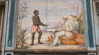 Aussenansicht des «Au Planteur». Auf die Fassade ist ein Schwarzer gemalt, der einem Kolonialherrn dient.