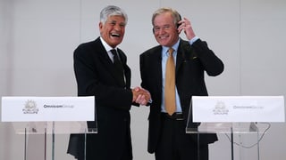 Die Chefs der beiden Werbeunternehmen Maurice Levy und John Wren geben sich lachend die Hand.