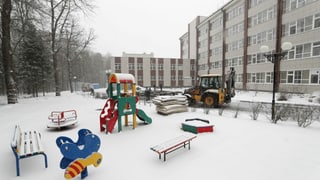 Leerer Spielplatz in Blocksiedlung in Moskau, Schnee