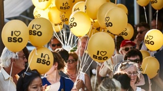 Menschen mit gelben I Love BSO Ballonen