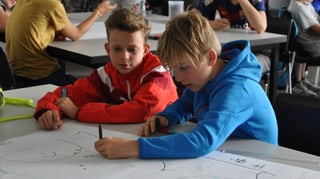 Schüler zeichnen am Pult Schüler zeichnen am Pult