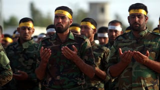 Schiitische Milizionäre halten im Gebet ihre Hände wie ein offenes Buch.