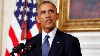 Obama spricht vor einer US-Flagge in ein Mikrofon. Obama spricht vor einer US-Flagge in ein Mikrofon.