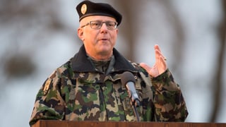 Mann in Tarnuniform an einem Rednerpult, er hat die linke Hand erhoben. Mann in Tarnuniform an einem Rednerpult, er hat die linke Hand erhoben.