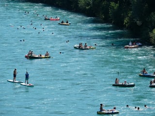 Boote und Schwimmer in einem Fluss
