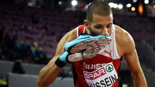 Kariem Hussein küsst seine Laufschuhe, die er in der rechten Hand hält. Kariem Hussein küsst seine Laufschuhe, die er in der rechten Hand hält.