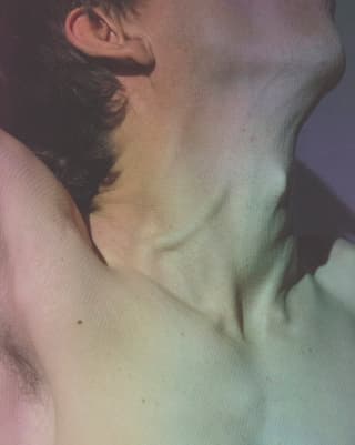 Nahaufnahme: Der Hals eines nackten Mannes.