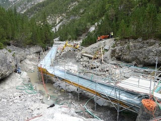 Für die Baustelle unterhalb der Staumauer des Lago di Livigno wurde das Bachbett in den letzten Wochen trockengelegt. Das Wasser wird über einen 60 Meter langen Holzkanal umgeleitet.