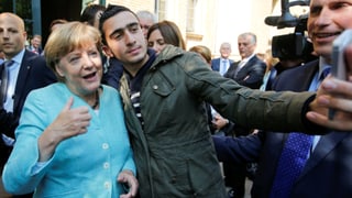 Angela Merkel posiert für ein Selfie mit einem Flüchtling Angela Merkel posiert für ein Selfie mit einem Flüchtling