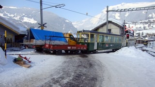 Der Zug und der Lieferwagen blockieren den Bahnübergang in Grindelwald.