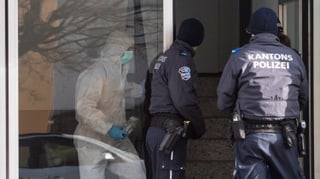 Drei Polizisten am Tatort in Hausen.
