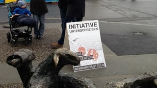 Plakat mit Werbung für Unterschriftensammlung steht auf der Strasse