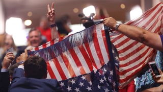 US-Flagge und jemand, der ein Victory-Zeichen macht.