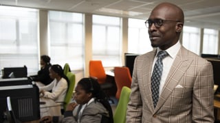 Ein Afrikaner in einem Anzug mit Krawatte in einem Büro.