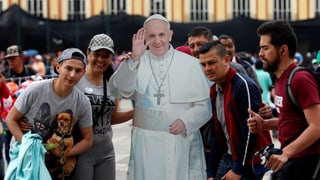 Junge Kolumbianer gruppieren sich um ein mannshohes Abbild aus Karton des Papstes.