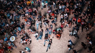 Dutzende Festivalbesucher sitzen am Boden