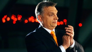 Ungarns Premier Viktor Orban klatscht vor dunklem Hintergrund in die Hände. (keystone)